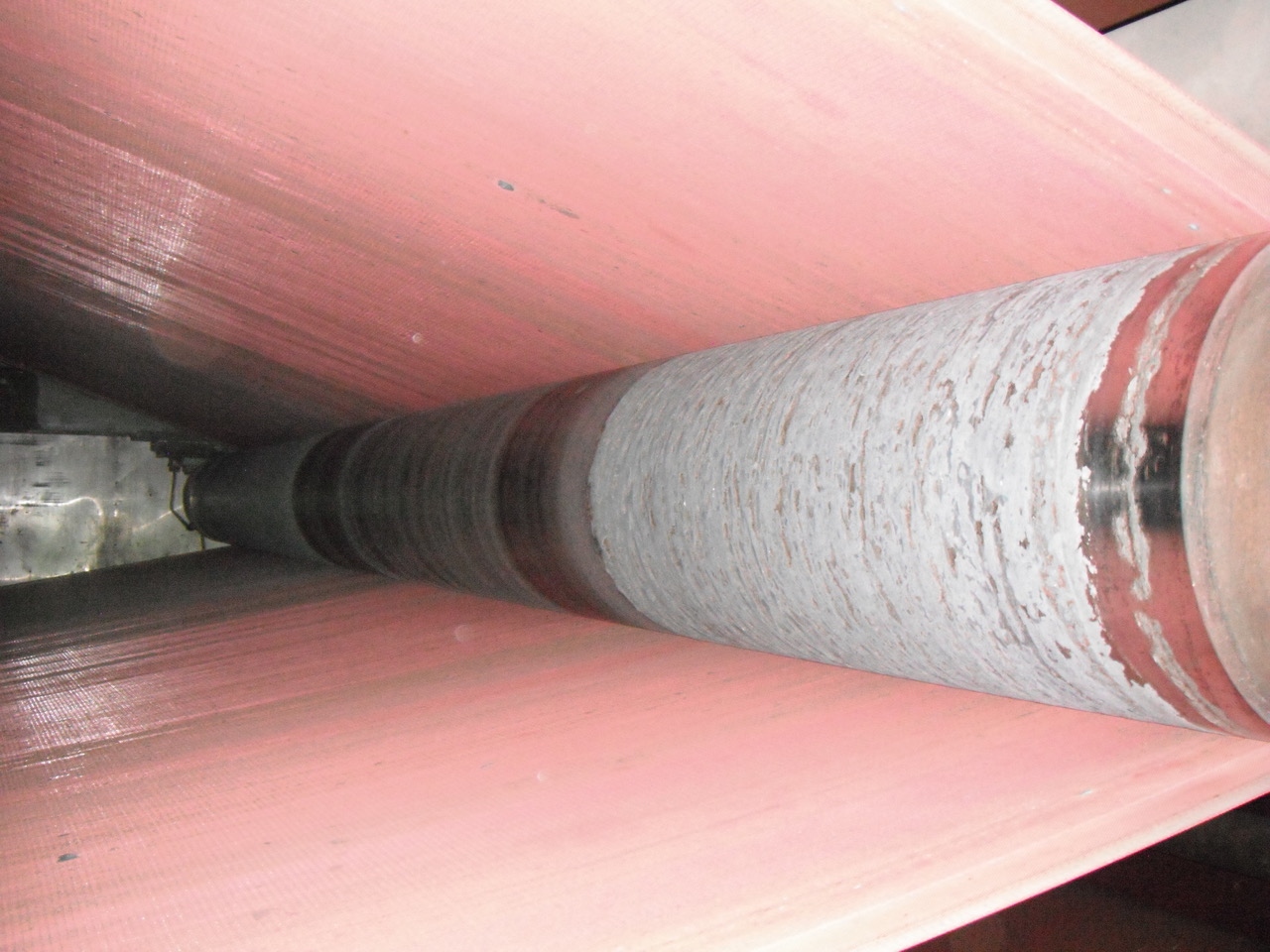 Paper machine dryer roll with heavy fiber and contaminant buildup before Fluoro-Stat conductive PTFE sleeve