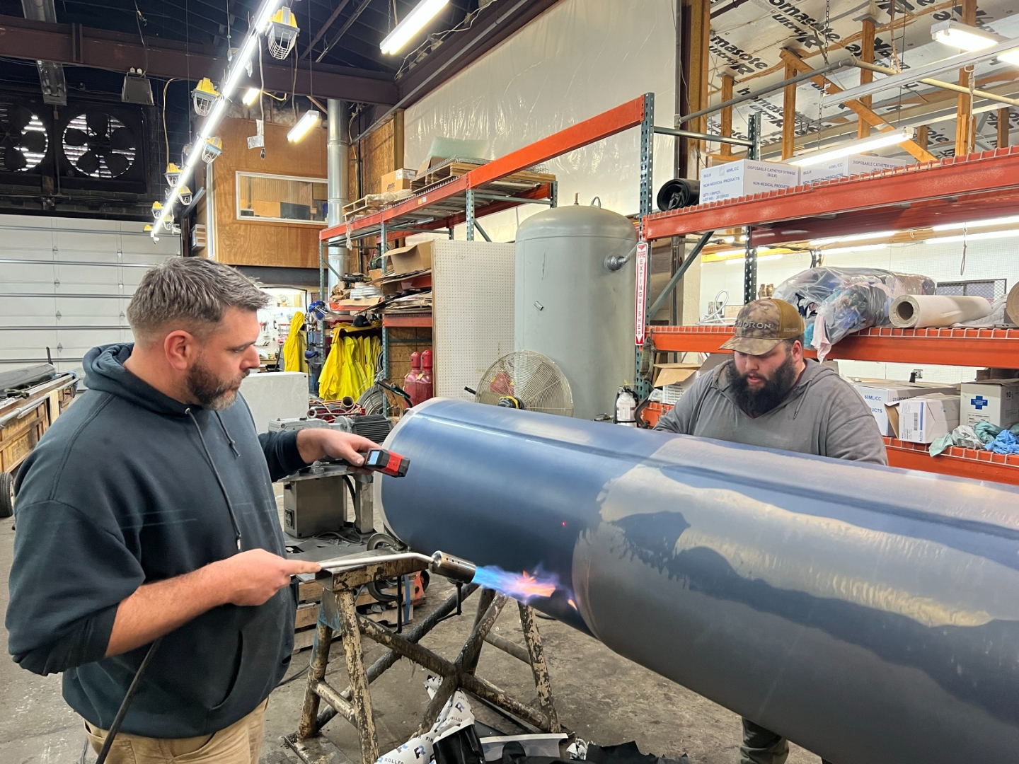 Fluoron technician heat shrinking a fluoropolymer roll cover onto an industrial roller